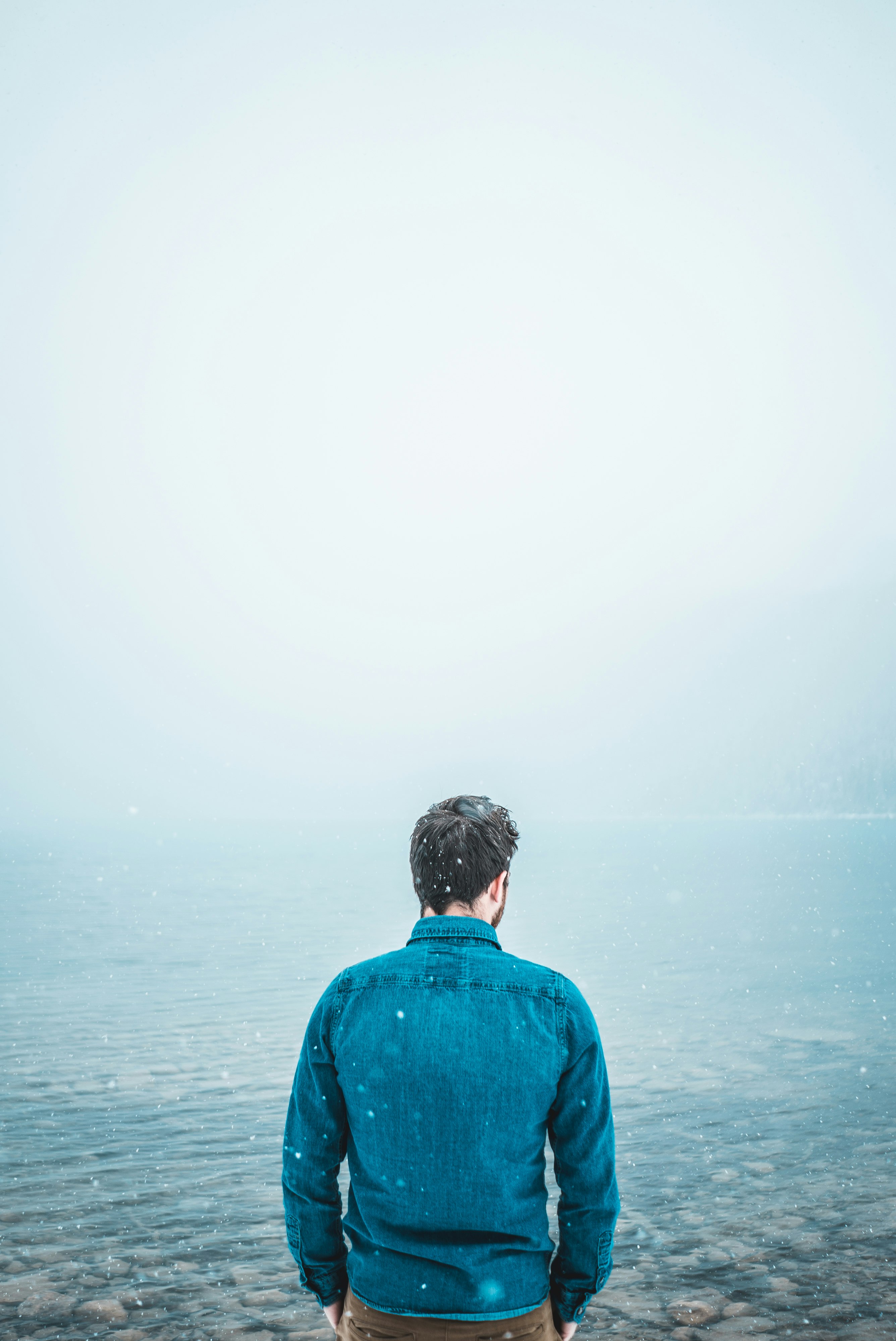 man standing in front of body of waterf